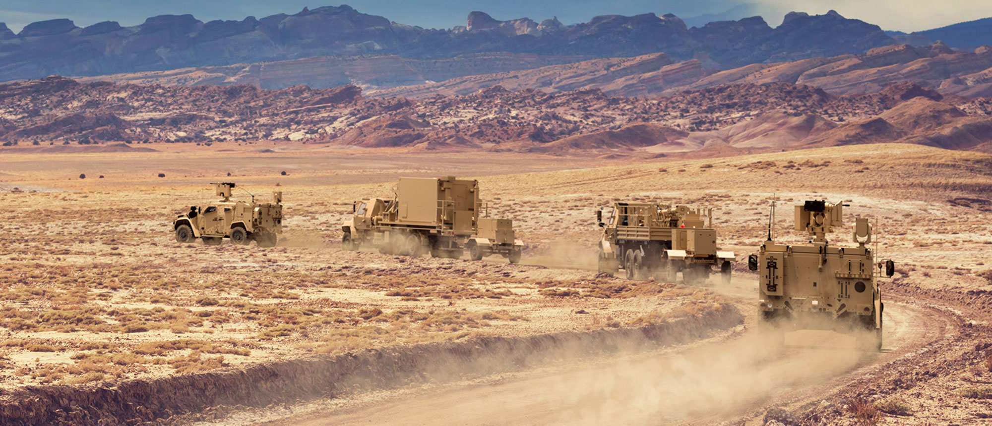 army truck convoy in mountainous desert