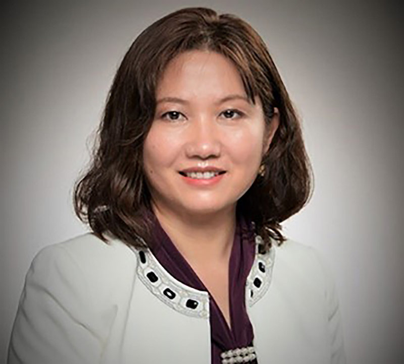 Professional portrait of a female engineer in a white jacket, representing innovation and leadership in microelectronics at Northrop Grumman.