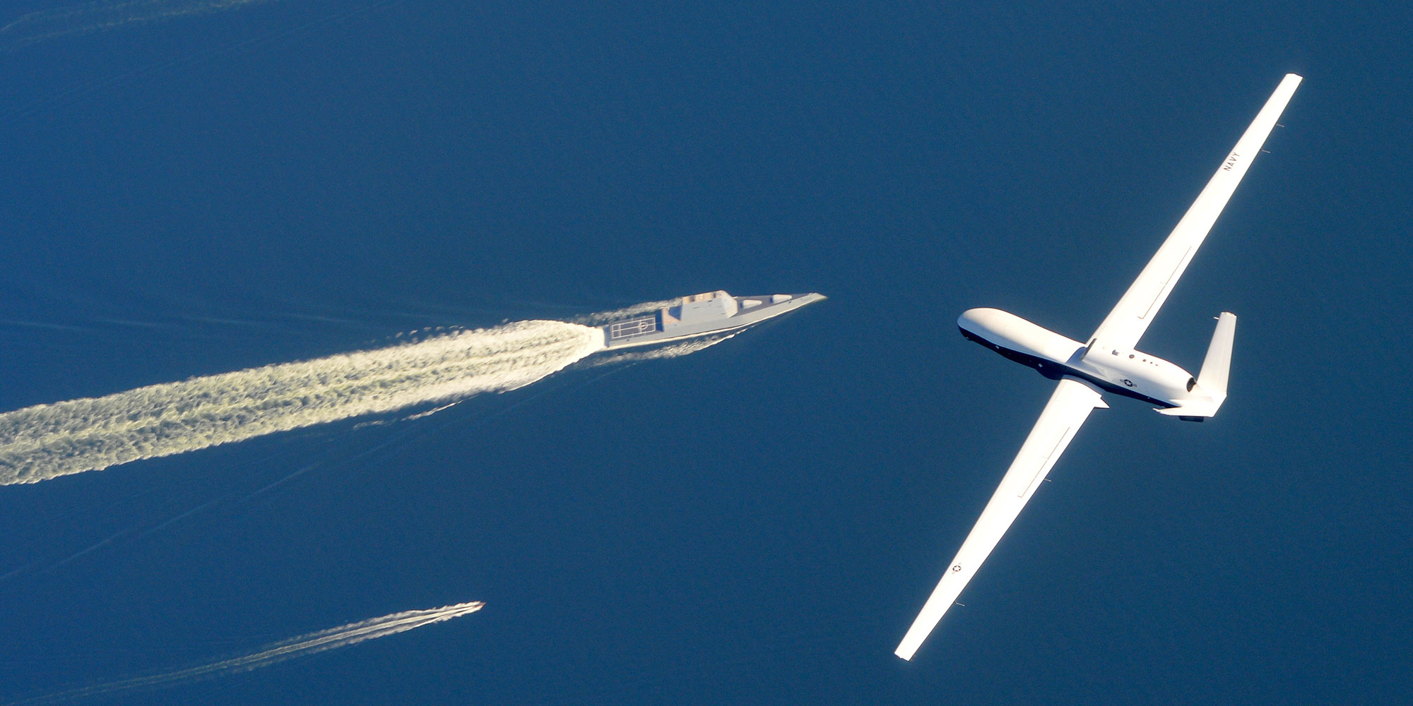 unmanned plane flying above navy ships