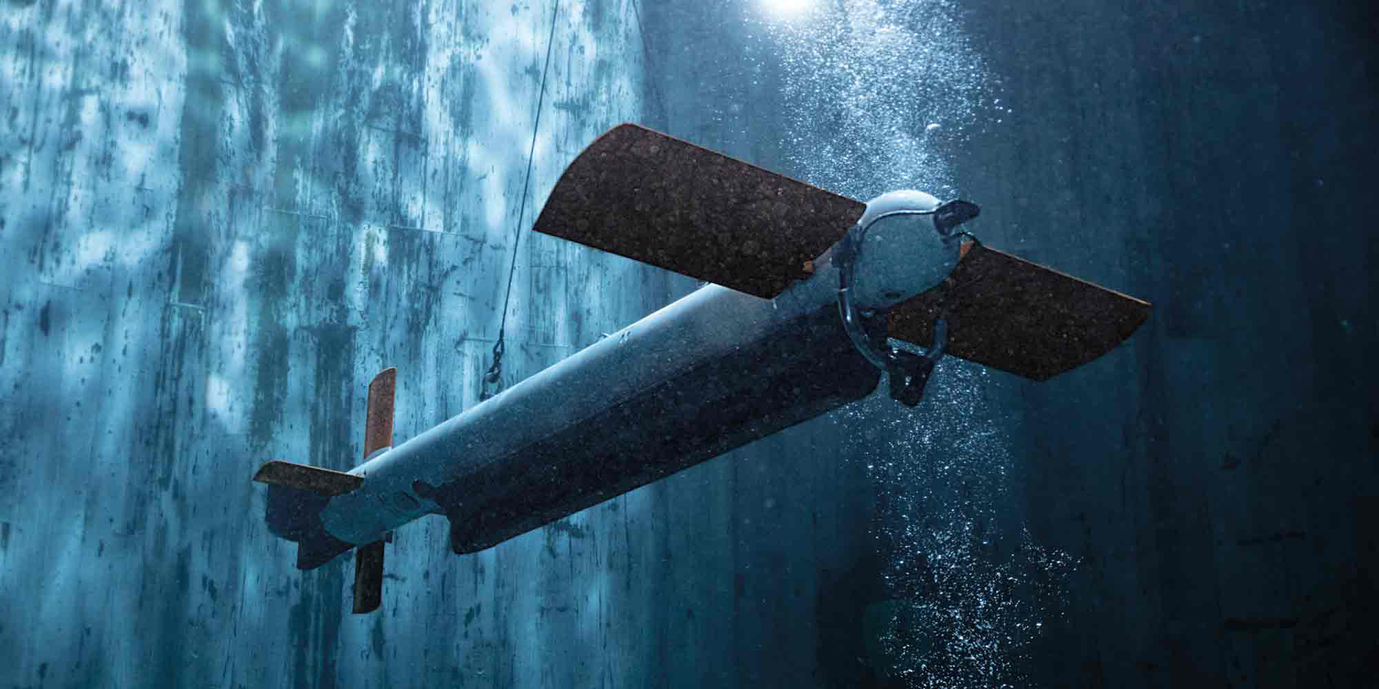 AQS-24B/C Minehunting System AQS-24B minehunting system operates underwater, showcasing its design and capabilities amid bubbles and illuminated water.