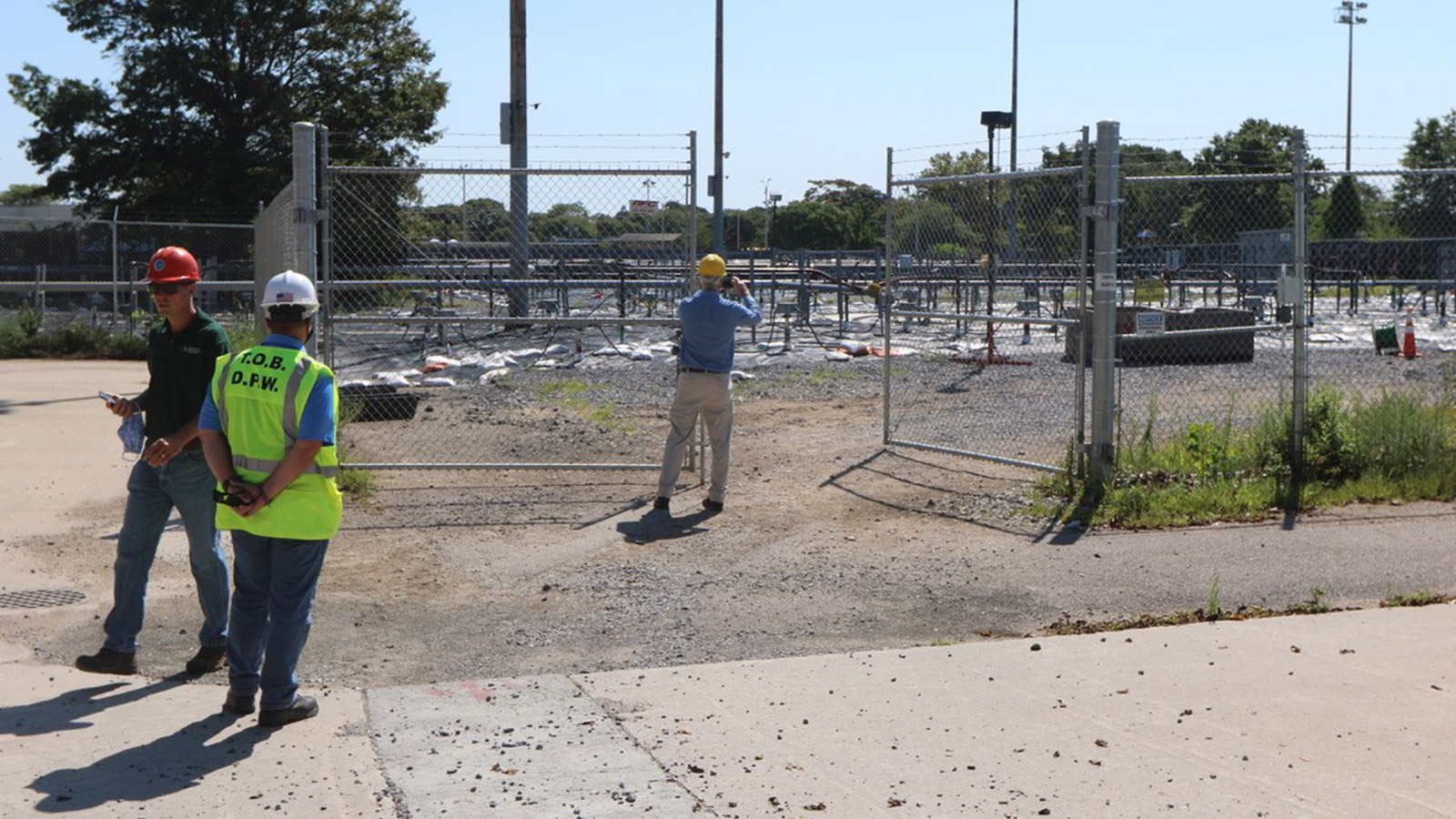 three men in hardhats near gravel bed