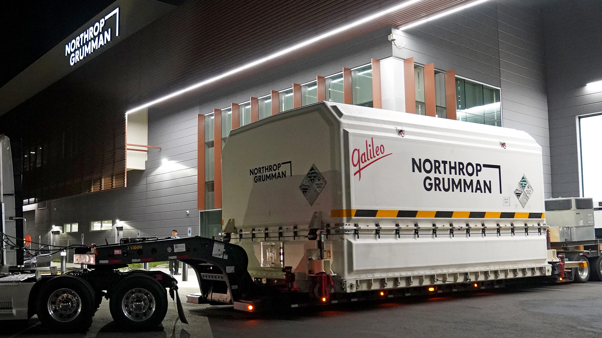 JPSS-2 leaving Northrop Grumman’s Gilbert, Arizona Satellite Manufacturing Facility 002 slide Tracker trailer driving packaged spacecraft from Northrop Grumman facility
